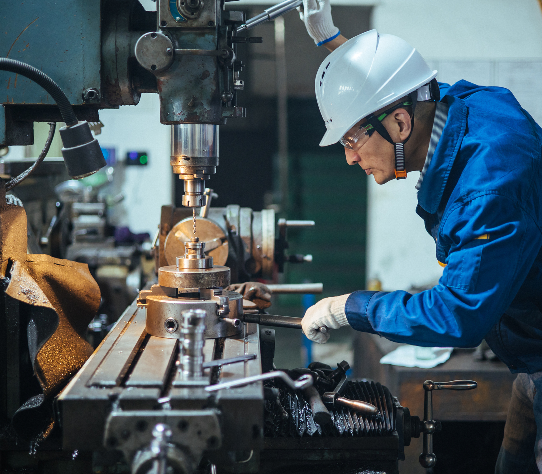 Engineer machining metal component in workshop